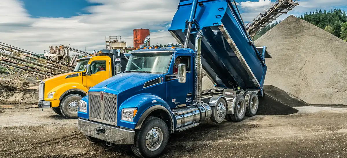 choose-the-right-dump-truck Two Kenworth T880 tri axle dump trucks operating on a job site.