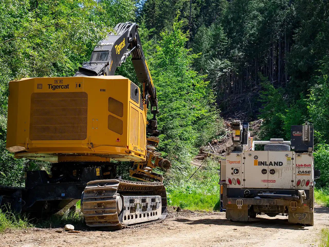 An Inland mobile repair service truck beside a Tigercat log processor.